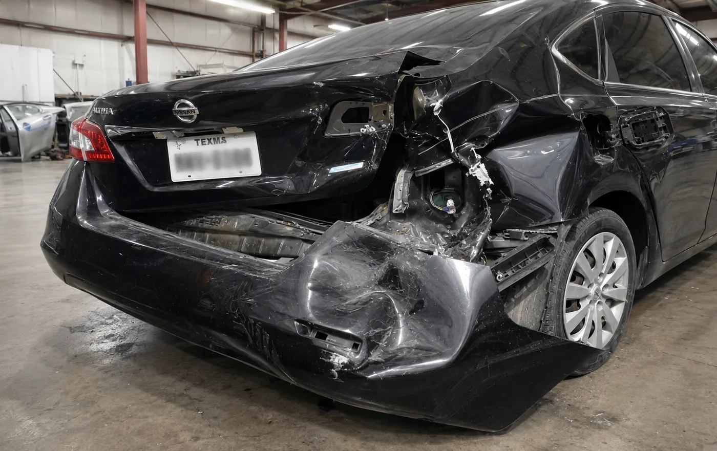Nissan Altima with severe rear-end damage, before repair